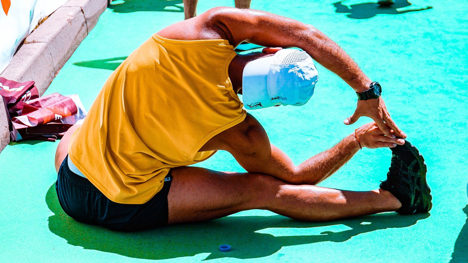 A man doing a seated hamstring stretch