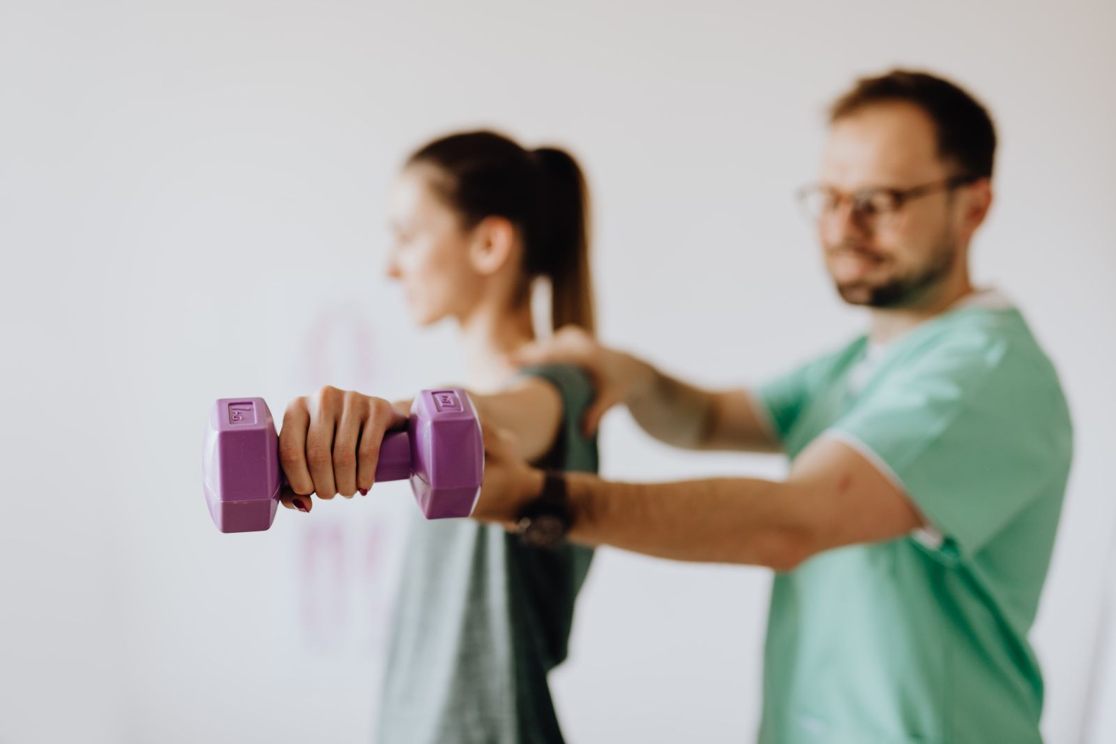 Guided arm-raise exercise with a light dumbbell for shoulder recovery