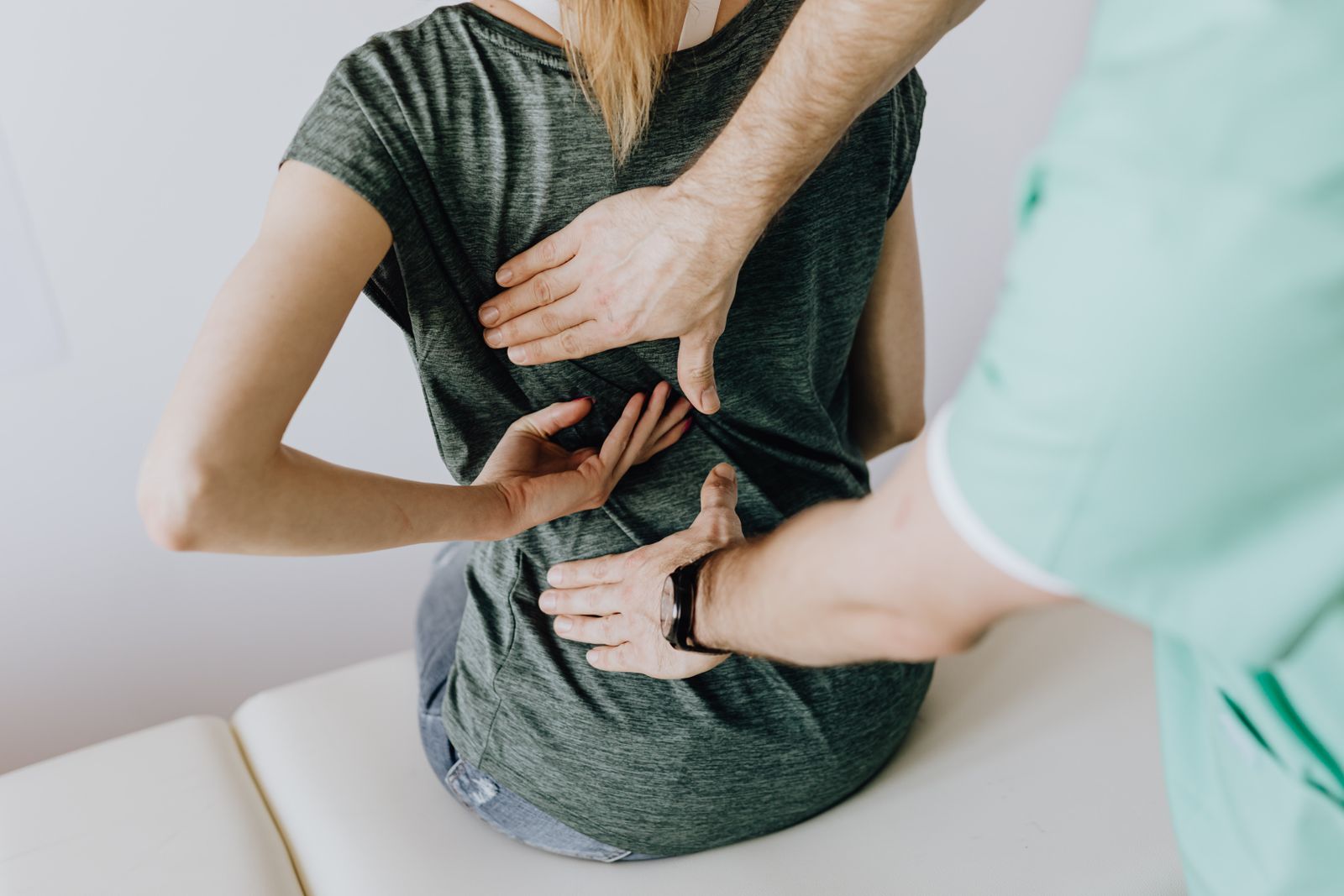 Physiotherapist assessing a patient's lower back