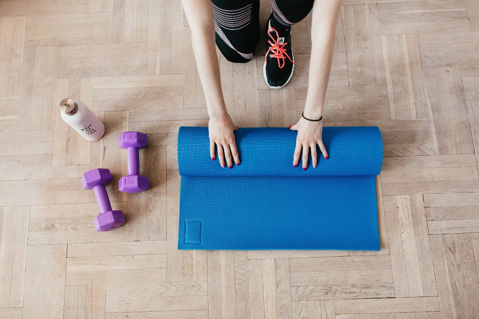 Exercise mat and dumbbells set up for a home knee-strengthening programme