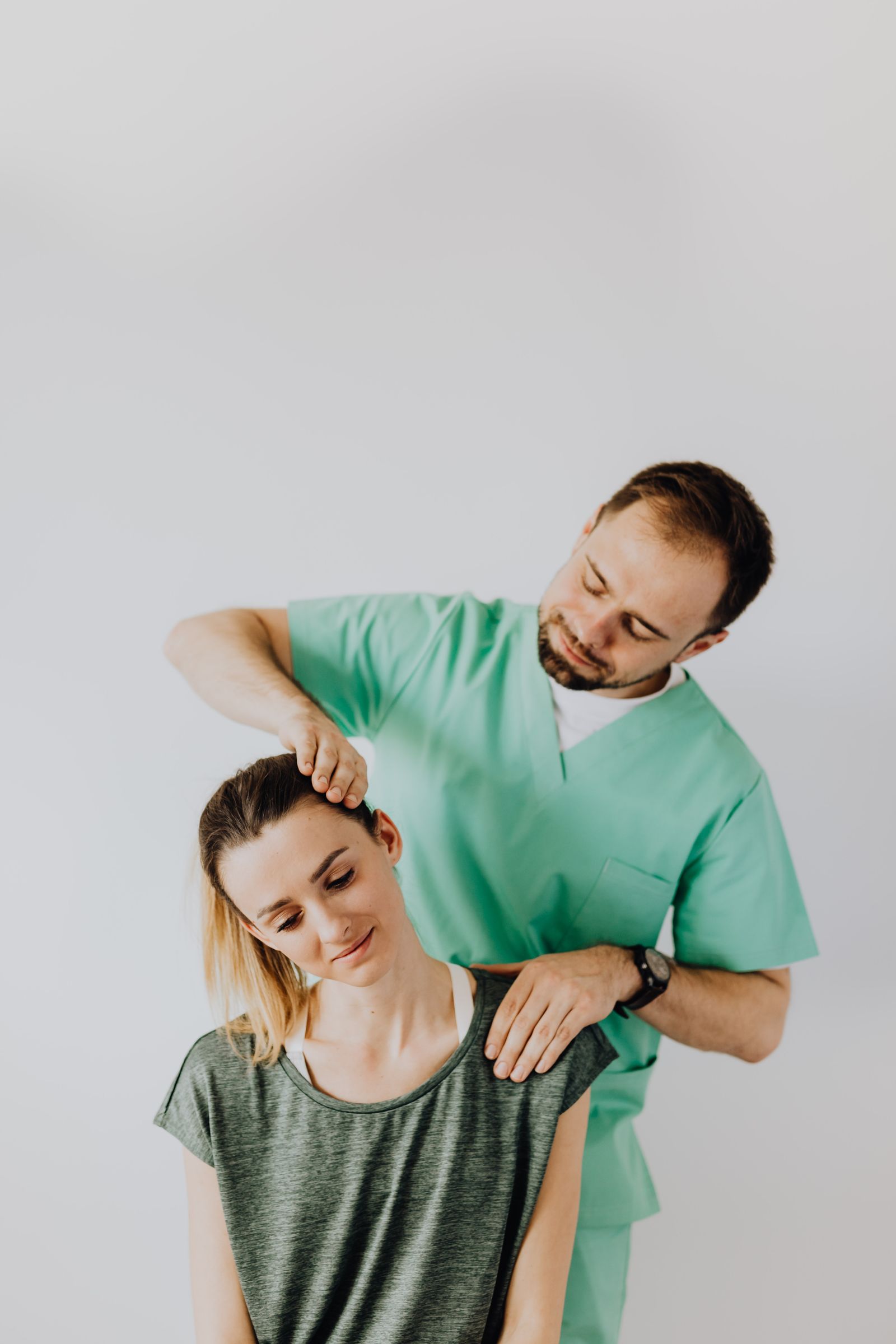 Physiotherapist gently stretching a patient's neck during treatment